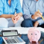 older couple with calculator and piggy bank