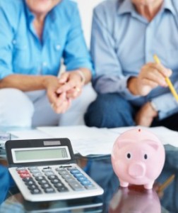 older couple with calculator and piggy bank